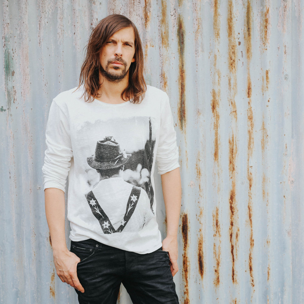 Model trägt ein lässiges Longsleeve mit einem Fotoprint eines Allgäuer Hirten