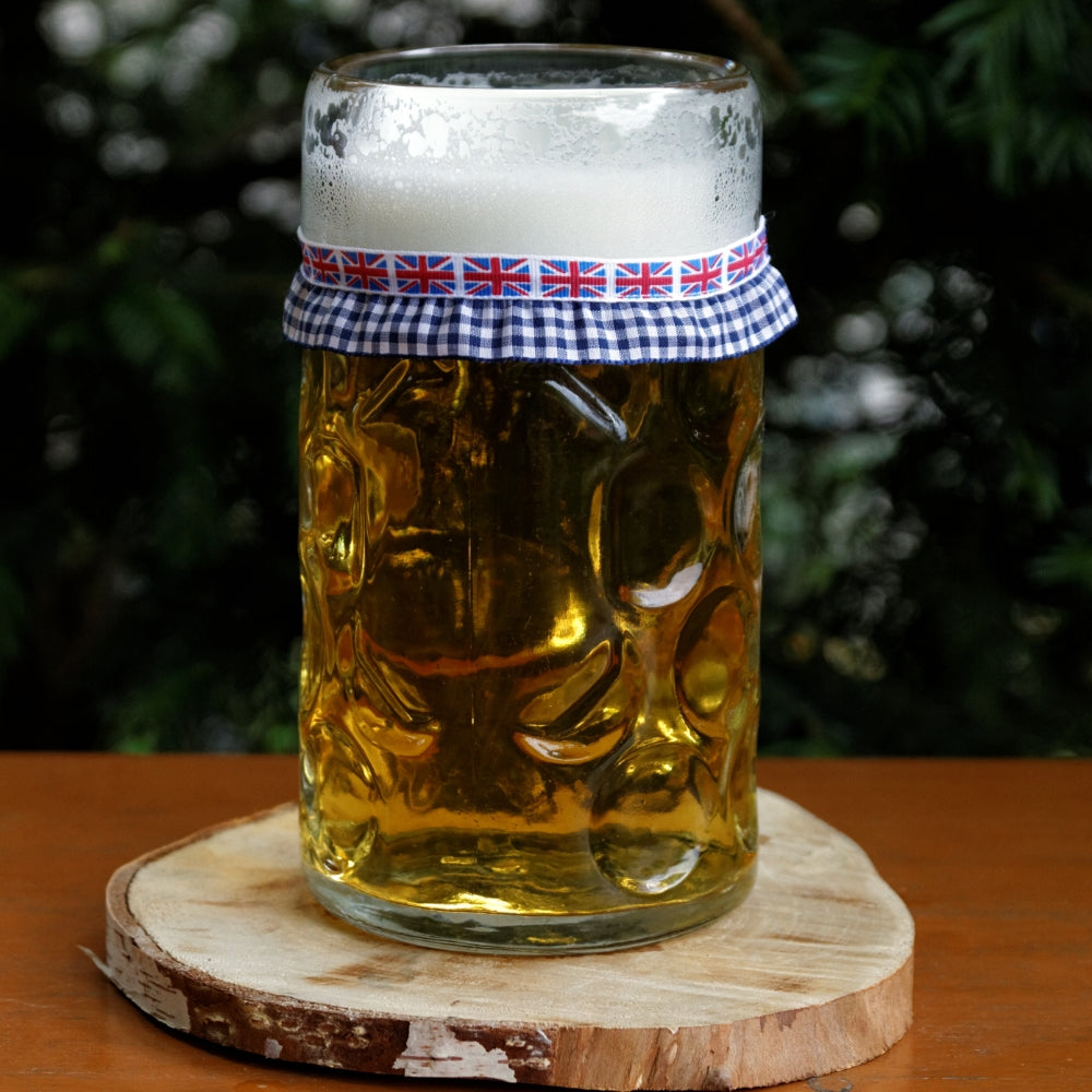 Mit Bier gefüllter Maßkrug mit Maßkrugband in UK-Flagge