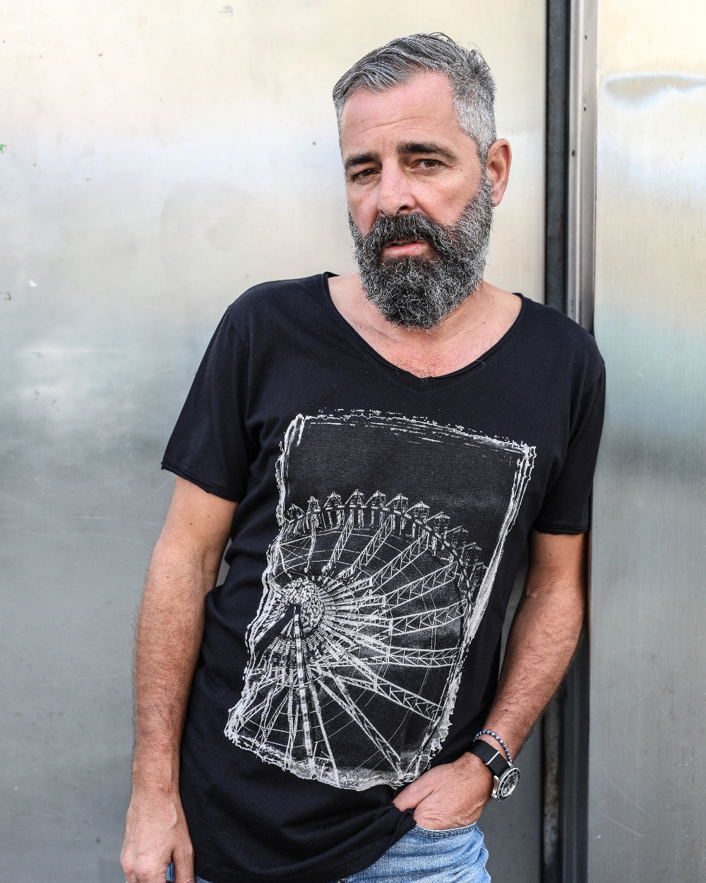 Männliches Model lehnt an einer Metall Türe mit dem Fotomotiv Shirt Riesenrad