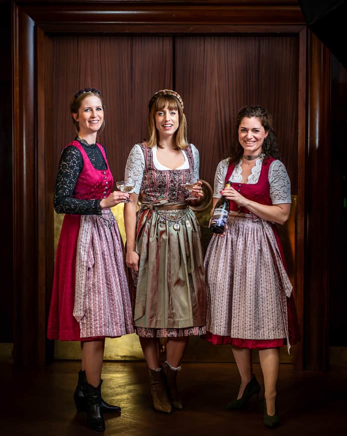 Drei Mädels tragen das vronikaa Wiesn Dirndl mit dem Charivari-Gürtel