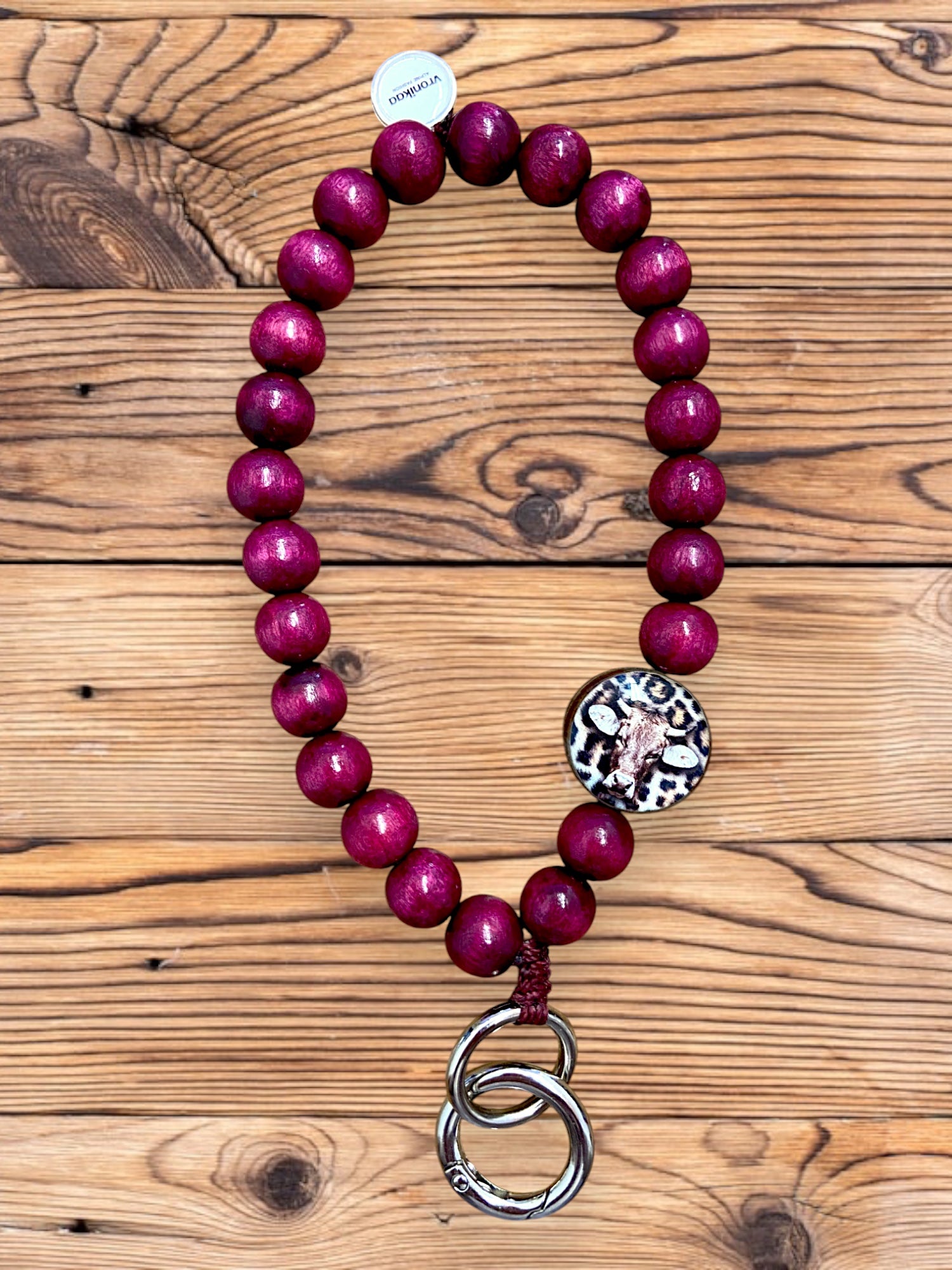 Schlüsselanhänger aus Holzperlen in der Farbe Berry mit Kuh-Motiv