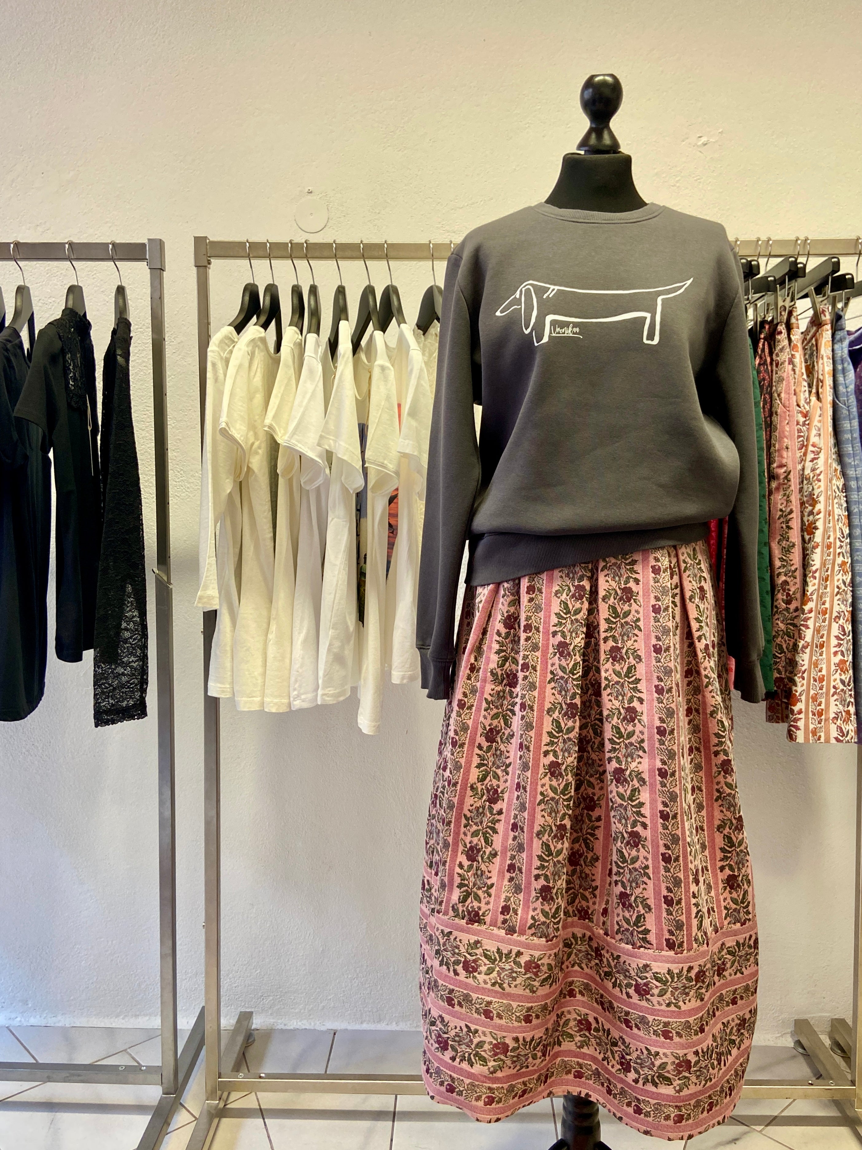 Eine Büste trägt das Sweatshirt mit dem Dackel Print Lotti dazu einen Trachtenrock mit Streifen und Blumen.