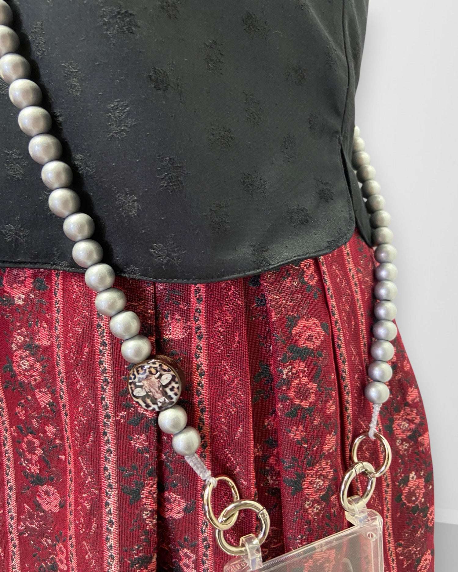 Detail-Aufnahme von der silbernen Handykette mit einem Kuh-Medaillon