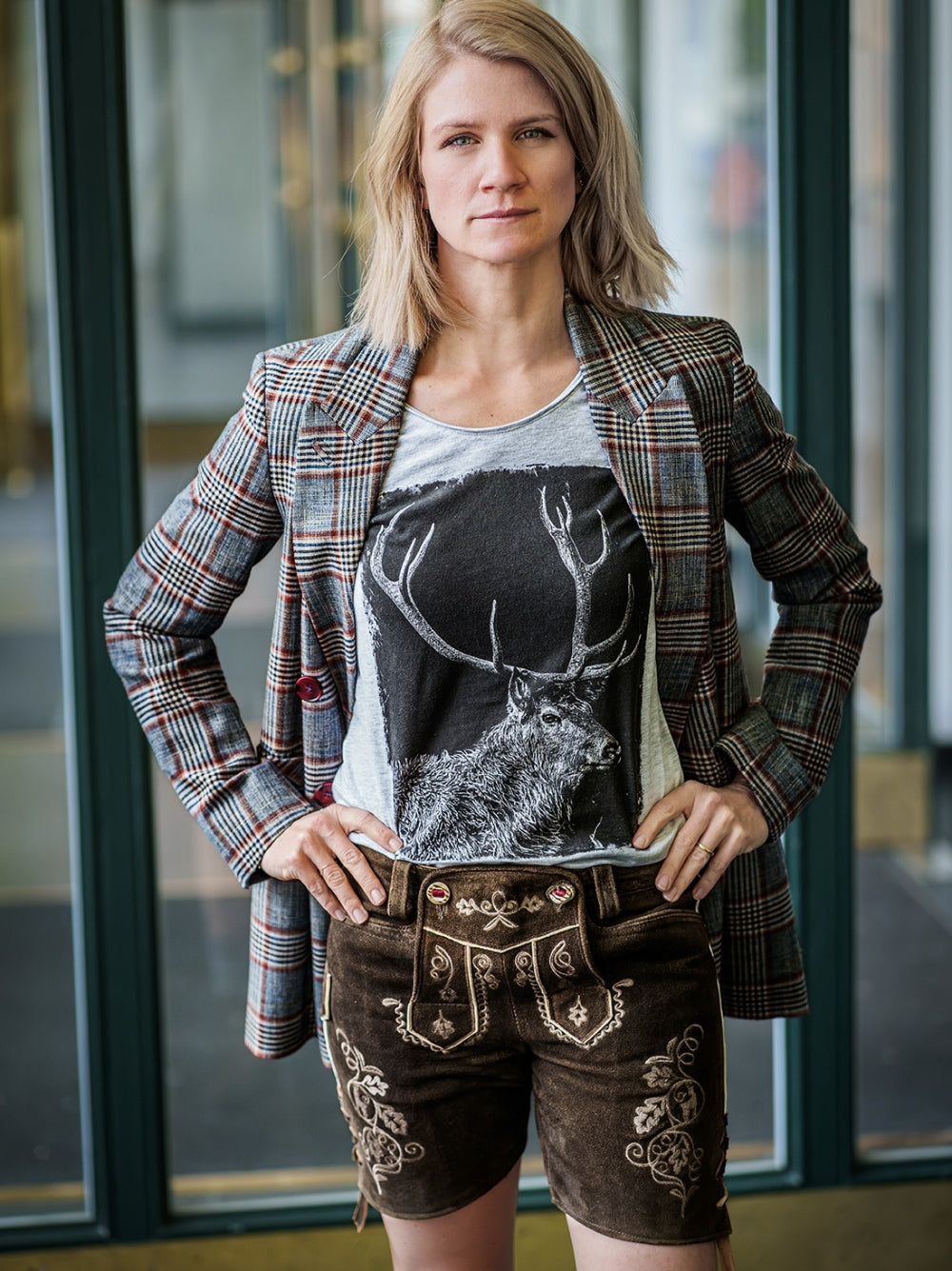 Model trägt eine Damen Lederhose von vronikaa und das Shirt Hirschgeweih mit einem karierten Blazer darüber