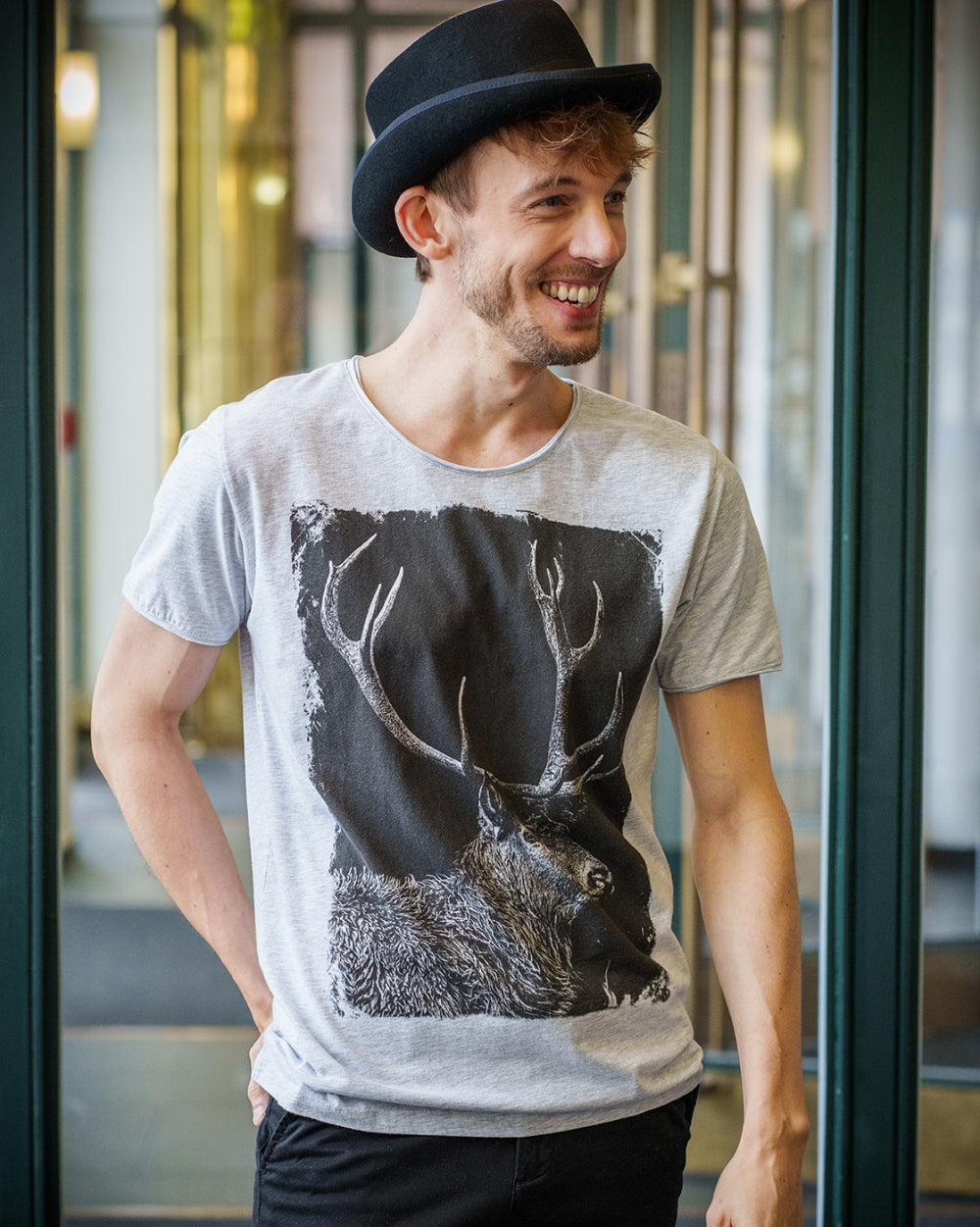 Model trägt einen Zylinder und das Shirt Hirschgeweih