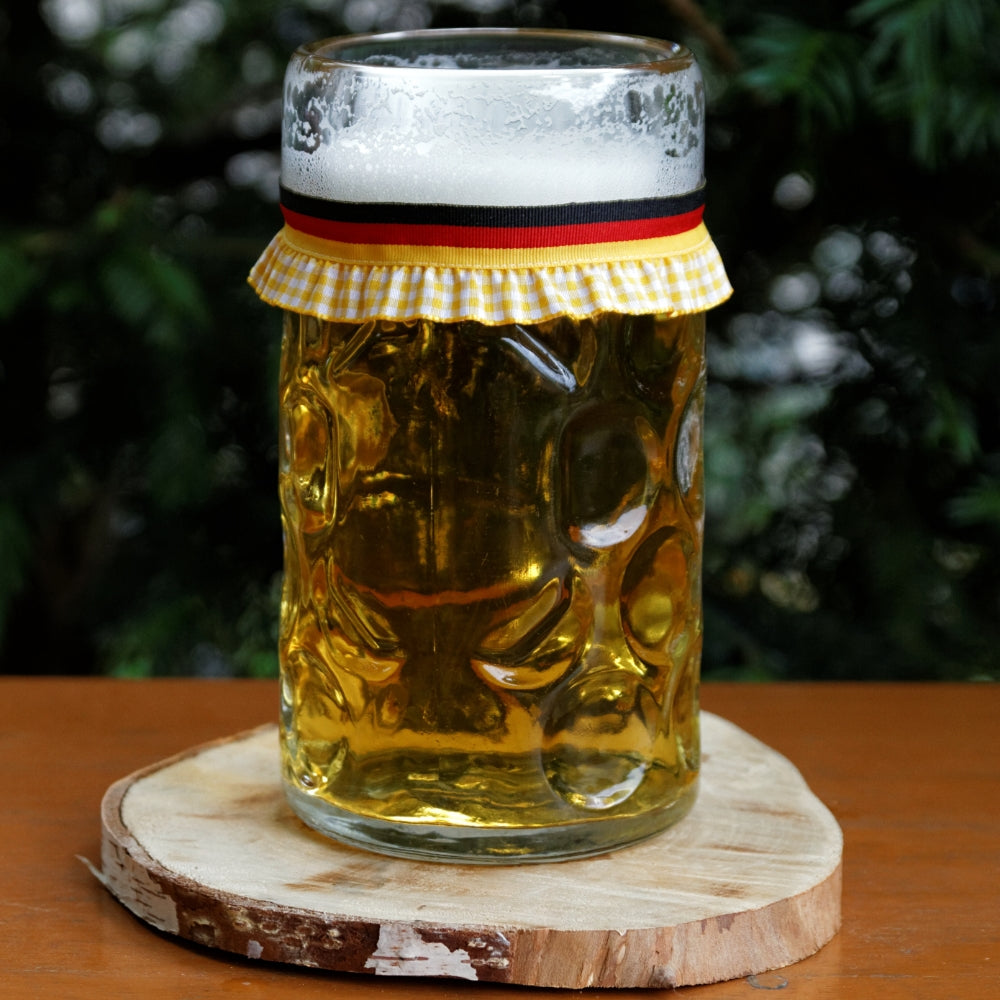 Mit Bier gefüllter Maßkrug mit Maßkrugband in Deutschland-Flagge