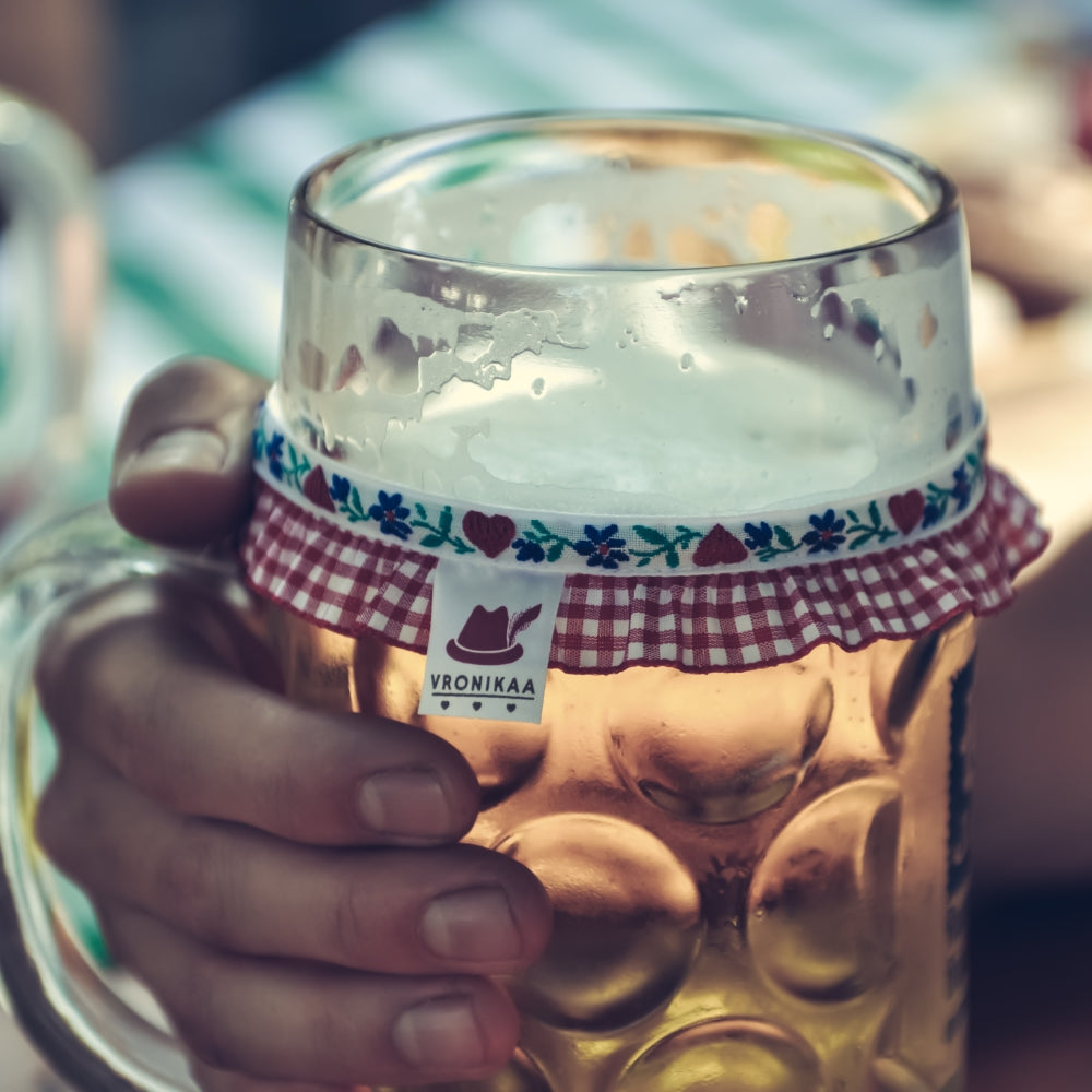 Maßkrug mit Bier gefüllt und einem Maßkrugband von Vronikaa